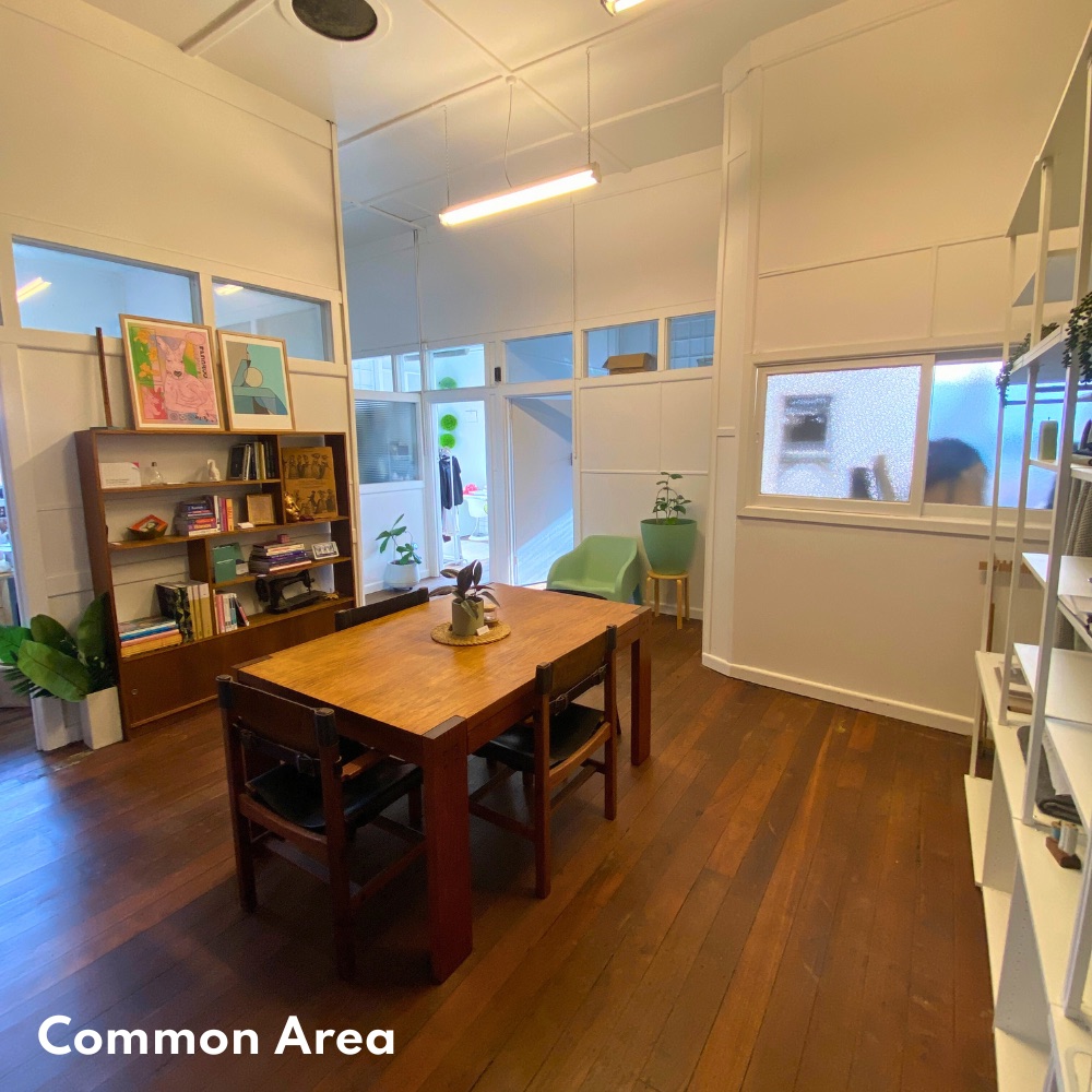 Common area with shared table, bookshelf and plants
