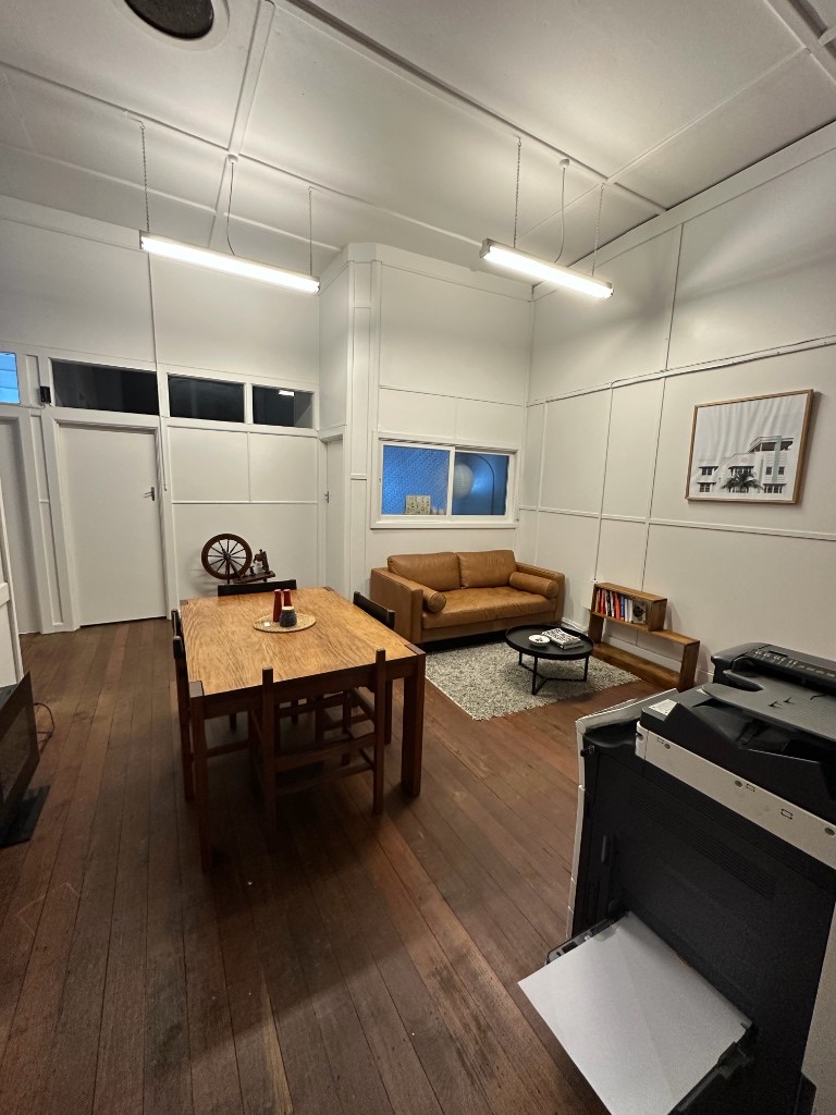Common room with leather sofa, timber table and office printer