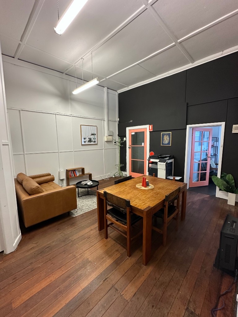Common area with coral studio doors, leather sofa and shared table