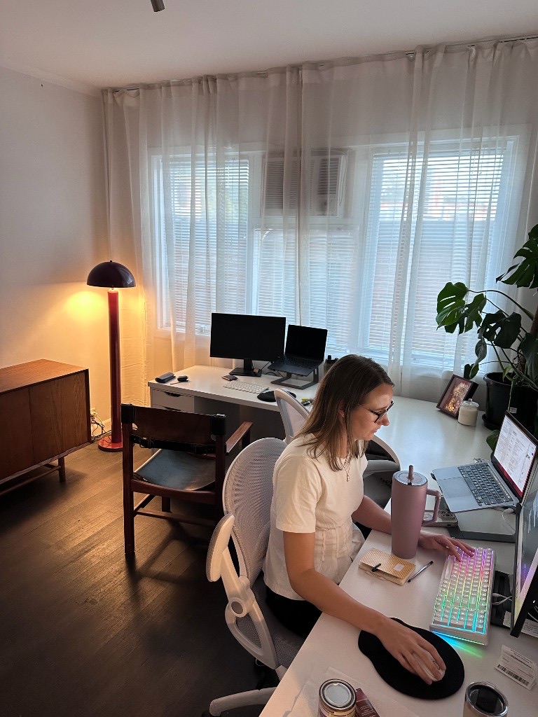 Member working at a desk in a warm, light-filled private studio